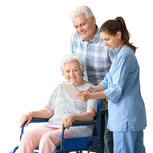 Opiekunka wspiera starszą kobietę na wózku inwalidzkim, obok stoi starszy mężczyzna.